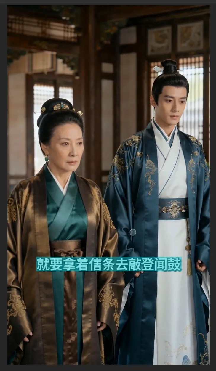 图片展示了一段古装剧画面,画面中有两位身着华丽古装的演员,一位身着深色古装,头戴发饰,另一位身着蓝白相间的古装,腰间系有装饰。画面底部有蓝色底白字的字幕,内容为“就要拿着信条去敲登闻鼓”。该图片与文档中“Seedance 2.0原生字幕消除”部分内容相关,用于说明此类字幕需去除,可推荐使用剪映里的AI消除功能等方法处理。